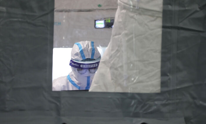 Técnico de laboratorio con equipo de protección personal en una instalación temporal de pruebas de Covid-19 en Xiamen, lugar del último brote epidémico de la provincia oriental china de Fujian, el 16 de septiembre de 2021. (STR/AFP vía Getty Images)