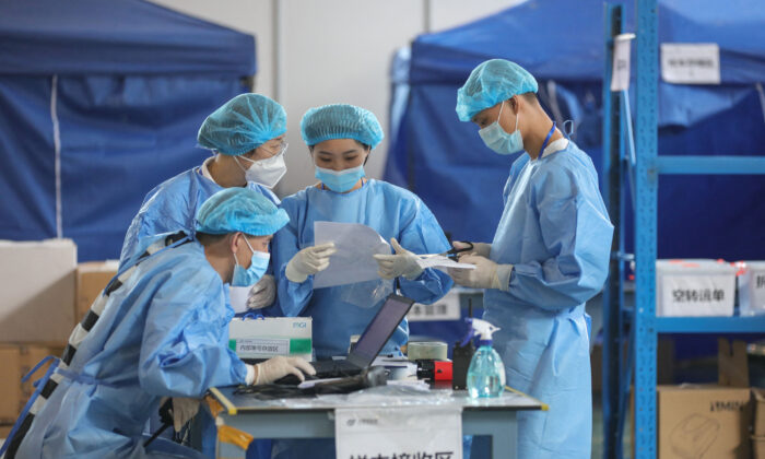 Técnicos de laboratorio con equipos de protección personal mientras trabajan en China. (STR/AFP vía Getty Images)