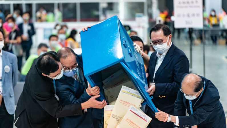 Funcionarios del gobierno abren una urna mientras comienza el recuento de votos en el Centro de Convenciones, durante las elecciones ordinarias del subsector del Comité Electoral 2021, el 19 de septiembre de 2021, en Hong Kong, China. (Anthony Kwan/Getty Images)