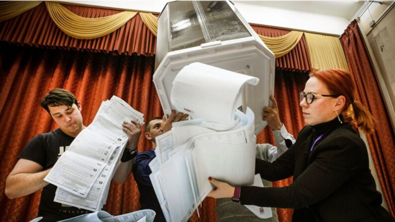 Miembros de una comisión electoral local vacían una urna en un colegio electoral tras la última jornada de las elecciones parlamentarias de tres días, en Moscú (Rusia), el 19 de septiembre de 2021. (Alexander Nemenov/AFP vía Getty Images)