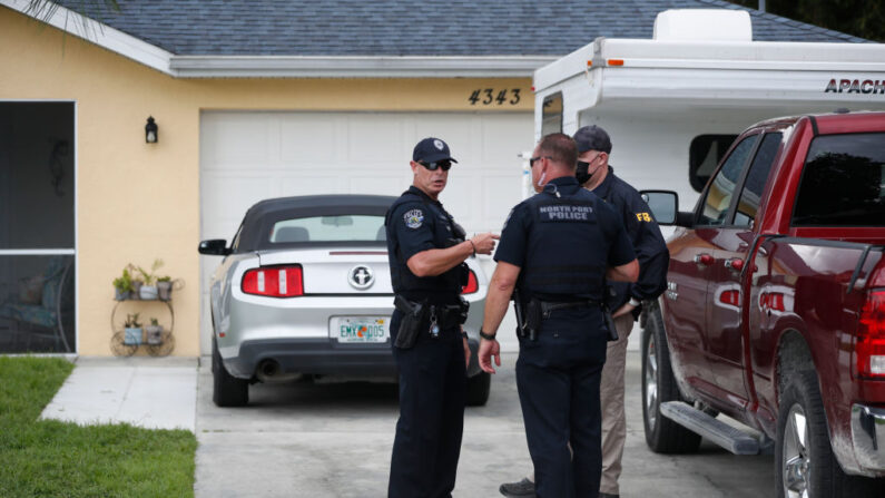 Un agente del FBI habla con un oficial de North Port mientras recogen pruebas en la casa de la familia de Brian Laundrie, que es una persona de interés después de que su prometida Gabby Petito desapareciera el 20 de septiembre de 2021 en North Port, Florida. (Octavio Jones/Getty Images)