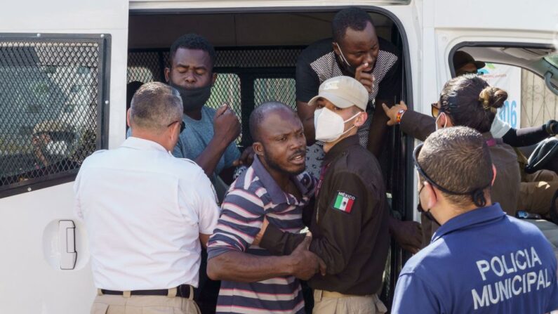 Hombres haitianos forcejean con funcionarios de inmigración mexicanos después de ser detenidos en la ciudad de Acuña, Coahuila, México, el 20 de septiembre de 2021. (PAUL RATJE/AFP vía Getty Images)