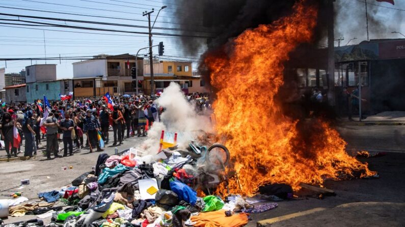 Manifestantes queman un campamento improvisado de migrantes venezolanos durante una marcha de protesta contra la migración ilegal en Iquique, Chile, el 25 de septiembre de 2021. (Martin Bernetti/AFP vía Getty Images)