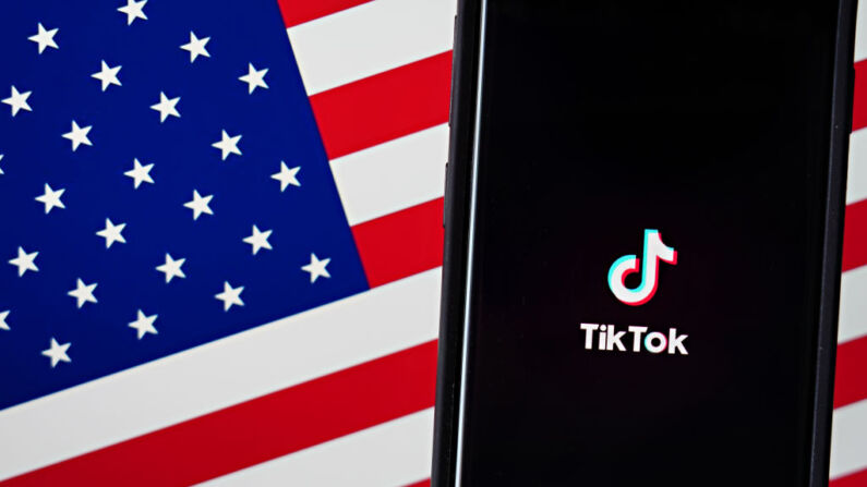 En esta ilustración fotográfica, se muestra un teléfono móvil con la aplicación TikTok, junto a la bandera estadounidense, el 3 de agosto de 2020 en la ciudad de Nueva York. (Cindy Ord/Getty Images)