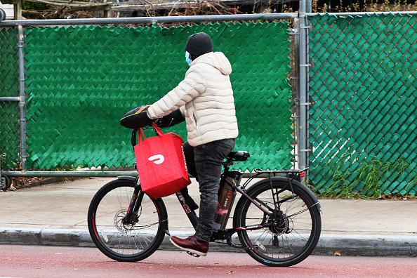 Un repartidor de Doordash conduce su bicicleta en Church Avenue en el vecindario Flatbush de Brooklyn, el 4 de diciembre de 2020 en la ciudad de Nueva York. (Foto de Michael M. Santiago/Getty Images)