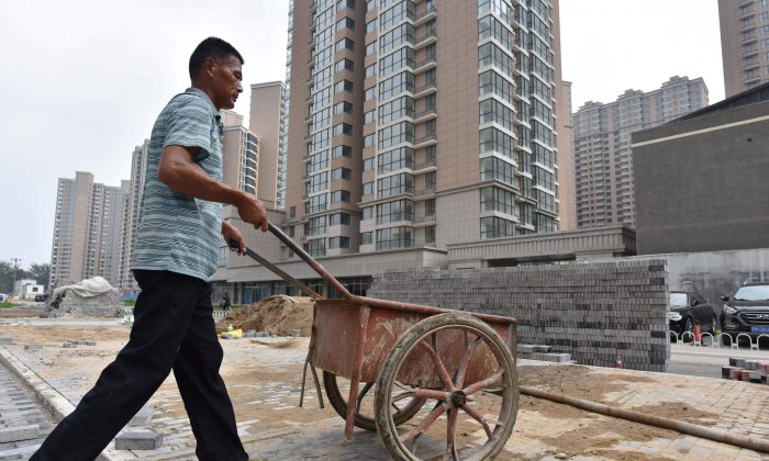 Un trabajador empuja un carro en el sitio de construcción de un complejo de viviendas, en Beijing, el 15 de agosto de 2017. (Greg Baker/AFP/Getty Images)