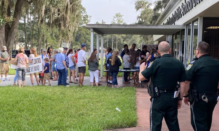 Unos ciudadanos hacen cola para asistir a una reunión de emergencia de la junta escolar con motivo de una propuesta de uso obligatorio de mascarilla para los niños en Hernando (Condado de Florida) el 31 de agosto de 2021. (Patricia Tolson/The Epoch Times)