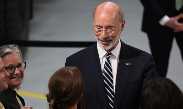 El gobernador de Pensilvania Tom Wolf saluda a varias personas en Mack Truck Lehigh Valley Operations en Macungie (Pensilvania) el 28 de julio de 2021. (Michael M. Santiago/Getty Images)