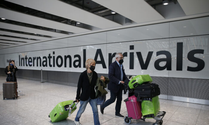 Unos viajeros salen por la puerta de llegadas internacionales del aeropuerto de Heathrow en Londres (Inglaterra) el 7 de agosto de 2021. (Hollie Adams/Getty Images)