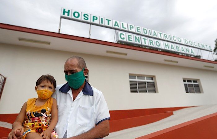 Un trabajador de la salud sostiene a un niño en sus piernas en la entrada de un hospital pediátrico hoy, en La Habana, Cuba. 3 de septiembre 2021. EFE/ Yander Zamora