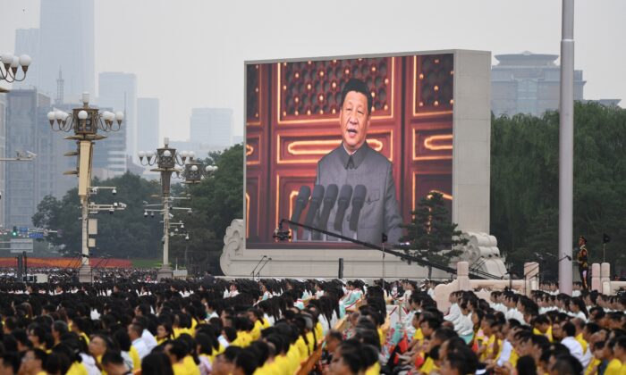 El líder chino Xi Jinping (en la pantalla) pronuncia un discurso durante las celebraciones del centenario de la fundación del Partido Comunista de China en la plaza de Tiananmen, en Pekín, el 1 de julio de 2021. (Wang Zhao/AFP vía Getty Images)