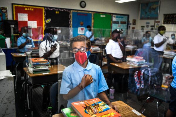 Los estudiantes usan mascarillas mientras asisten a su primer día de clases después de las vacaciones de verano en la Escuela Católica de San Lorenzo al norte de Miami, el 18 de agosto de 2021. (Chandan Khanna/AFP vía Getty Images)
