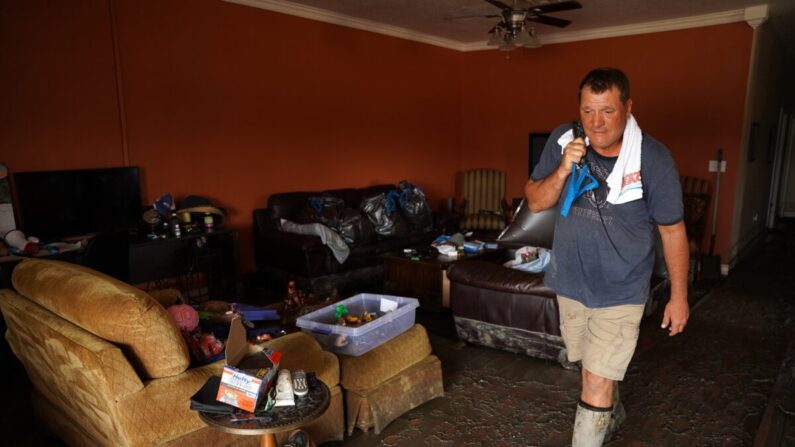 Shane Holder trabaja en la limpieza de su residencia dañada por la tormenta, donde él y su esposa dirigían un parque de vehículos recreativos en la playa, en Grand Isle (Luisiana), el 3 de septiembre de 2021. (Sean Rayford/Getty Images)