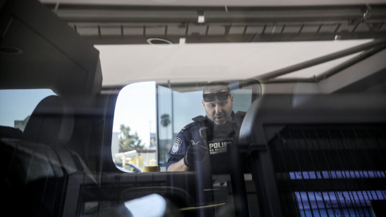 Un agente del Servicio de Inmigración y Control de Aduanas (ICE) revisa un automóvil en la frontera entre Estados Unidos y México. (Foto de archivo/Sandy Huffaker/AFP a través de Getty Images)