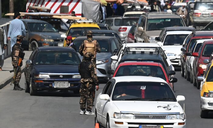 Varios terroristas talibanes hacen guardia mientras controlan a los viajeros en un puesto de control de carretera en Kabul el 4 de septiembre de 2021. (Aamir Qureshi/AFP vía Getty Images)