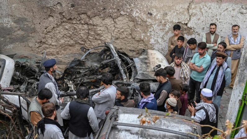 Los residentes afganos y familiares de las víctimas se reúnen junto a un vehículo dañado dentro de una casa, un día después de un ataque aéreo con drones estadounidenses en Kabul, Afganistán, el 30 de agosto de 2021. (Wakil Kohsar/AFP a través de Getty Images)
