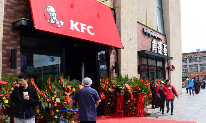 La gente pasa por delante de un restaurante de comida rápida KFC en Lhasa, Tíbet, el 8 de marzo de 2015. (STR/AFP vía Getty Images)