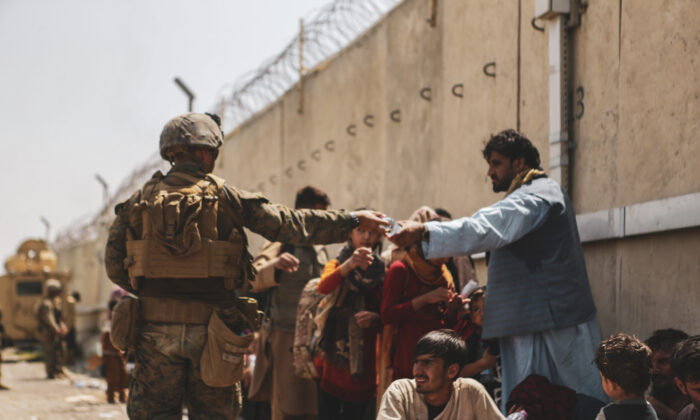Esta imagen muestra a un infante de marina con la 24° Unidad Expedicionaria de Infantería de Marina repartiendo agua a los evacuados afganos, en el Aeropuerto Internacional Hamid Karzai, en Kabul, Afganistán, el 22 de agosto de 2021. (Sargento Isaiah Campbell/Cuerpo de Marines de EE.UU. a través de Getty Images)
