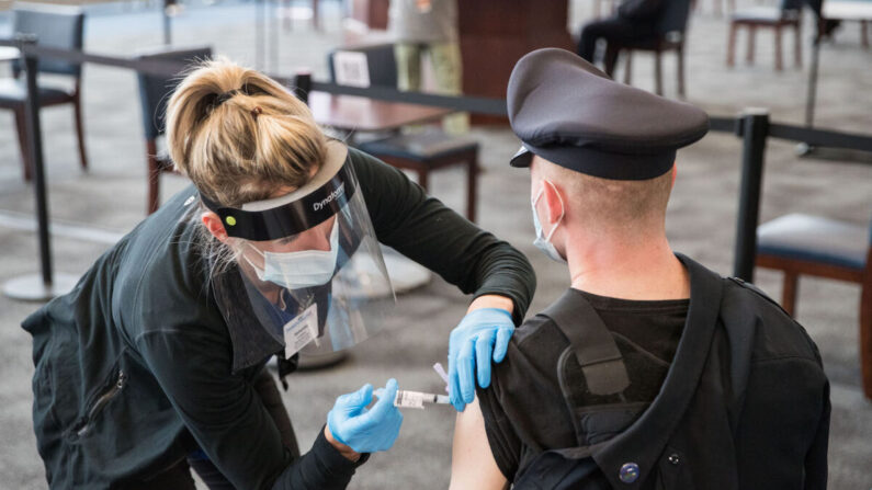 Un policía recibe su vacuna COVID-19 en Foxborough, Massachusetts, el 15 de enero de 2021. (Scott Eisen/Getty Images)