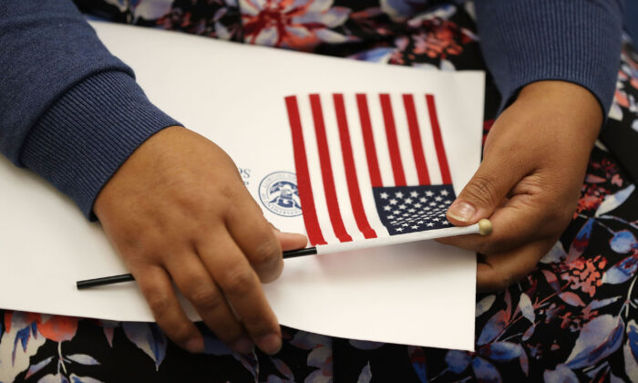 Una persona sostiene una bandera estadounidense en una ceremonia de naturalización del Servicio de Ciudadanía e Inmigración de Estados Unidos en Miami, Florida el 17 de agosto de 2018. (Joe Raedle/Getty Images)