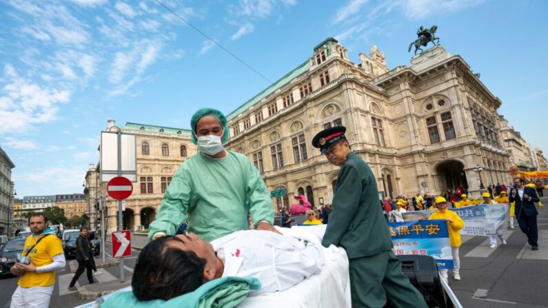 Practicantes de Falun Gong en Viena, Austria, hacen una demostración sobre la sustracción de órganos a practicantes encarcelados en China durante una protesta contra la importación de órganos humanos de China a Austria, el 1 de octubre de 2018. (JOE KLAMAR/AFP vía Getty Images)