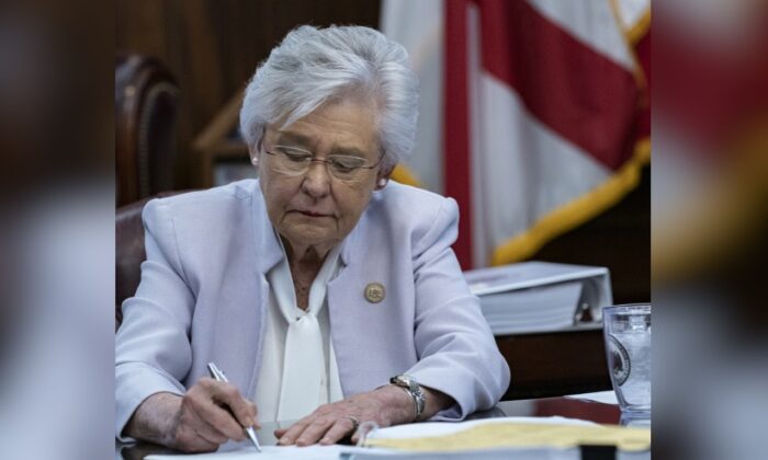 La gobernadora de Alabama, Kay Ivey, firma un proyecto de ley para prohibir los pasaportes con vacunas el 24 de mayo de 2021. (Cortesía de la oficina de la gobernadora Kay Ivey)