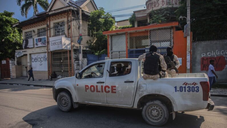 Policías armados viajan en la parte trasera de una camioneta después de que las calles de la capital haitiana, Puerto Príncipe, quedaran desiertas tras la convocatoria de una huelga general lanzada por varias asociaciones profesionales y empresas para denunciar la inseguridad en Puerto Príncipe tras el secuestro de 17 extranjeros, el 18 de octubre de 2021. (Richard Pierrin/AFP vía Getty Images)