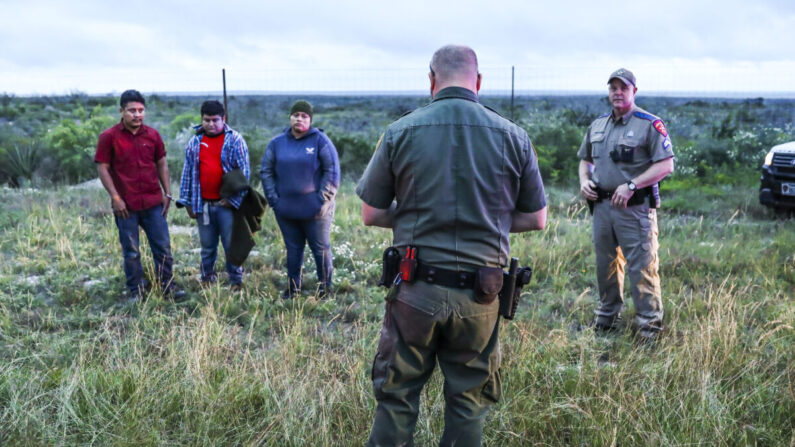 Un agente de la Patrulla Fronteriza recoge a tres extranjeros ilegales en el condado de Kinney, Texas, el 20 de octubre de 2021, después de que las tropas estatales de Texas arrestaran a dos contrabandistas estadounidenses que los transportaban a San Antonio. (Charlotte Cuthbertson/The Epoch Times)