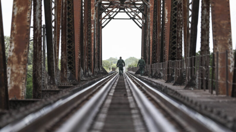 Agentes de la Patrulla Fronteriza buscan extranjeros ilegales alrededor del lecho de un río desde un puente ferroviario cerca de Uvalde, Texas, el 25 de agosto de 2021. (Charlotte Cuthbertson/The Epoch Times)