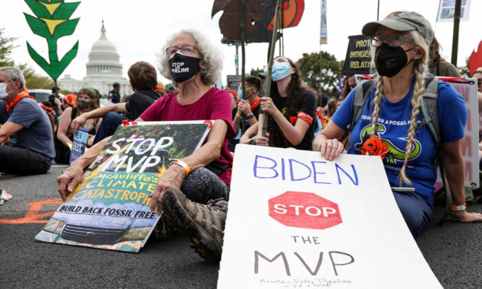 Varios activistas por el clima se sientan en una intersección mientras participan en un acto de desobediencia civil durante una protesta en el Capitolio el 15 de octubre de 2021 en Washington, DC. (Foto de Alex Wong/Getty Images)