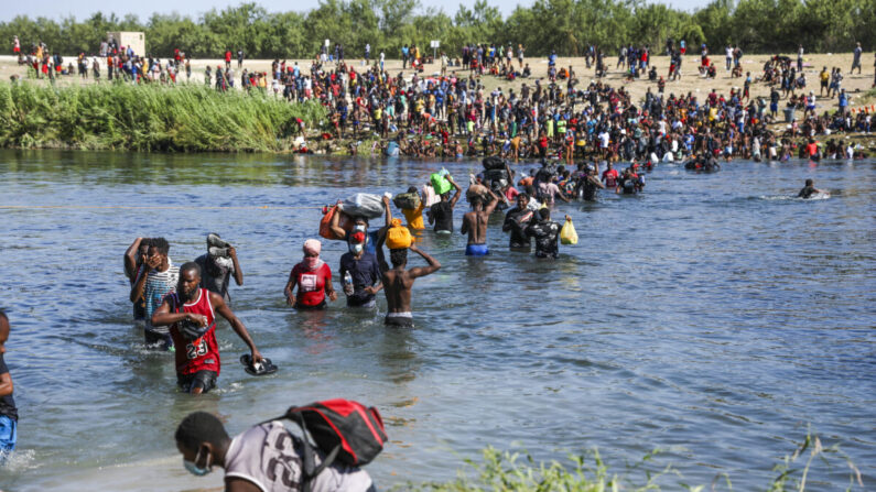 Inmigrantes ilegales transportan suministros de ida y vuelta entre Acuña, México y los Estados Unidos a través del Río Grande, la frontera internacional con México, en Acuña, México, el 20 de septiembre de 2021. (Charlotte Cuthbertson/The Epoch Times)