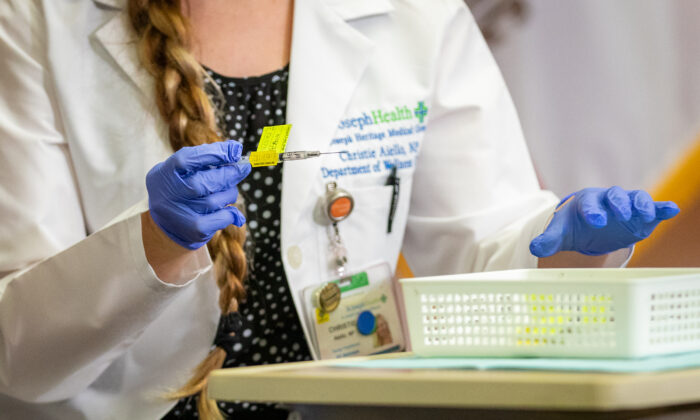 Un trabajador médico se prepara para administrar una vacuna COVID-19 en Orange, California, el 16 de diciembre de 2020. (John Fredricks/The Epoch Times)