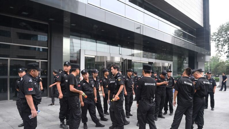 Personal de seguridad frente a la Comisión Reguladora de la Banca de China en Beijing, China, el 6 de agosto de 2018, después de que la policía china sofocara agresivamente una protesta planeada contra las pérdidas sufridas por las plataformas de préstamos entre particulares (P2P). (GREG BAKER/AFP a través de Getty Images)