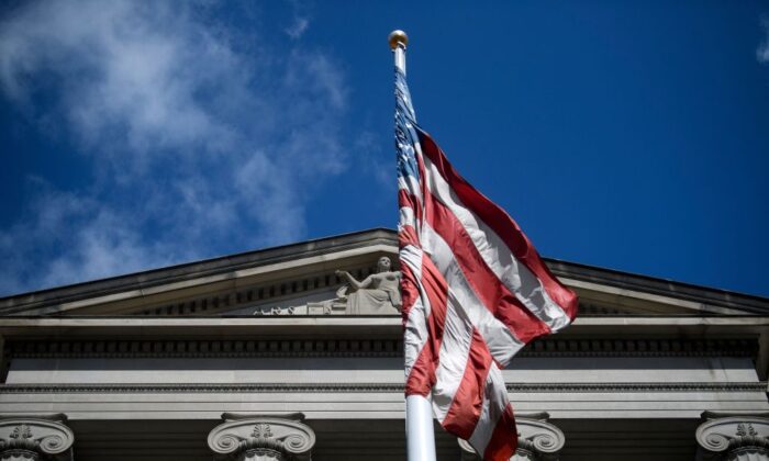 La bandera de EE. UU. ondea frente al Departamento de Justicia de EE. UU., en Washington, DC el 22 de marzo de 2019. (Brendan Smialowski/AFP/Getty Images)