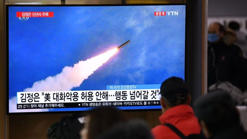 Varias personas observan desde una estación de tren en Seúl, un programa de noticias de televisión que muestra imágenes de archivo de una prueba de misiles de Corea del Norte, el 1 de enero de 2020. (Jung Yeon-je/AFP vía Getty Images)