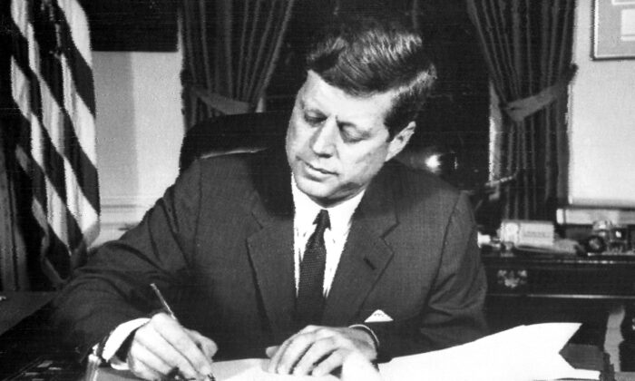 El presidente de EE. UU. John F. Kennedy firma la orden que establece el bloqueo naval de Cuba el 24 de octubre de 1962, durante la crisis de los misiles en Cuba. (AFP vía Getty Images)