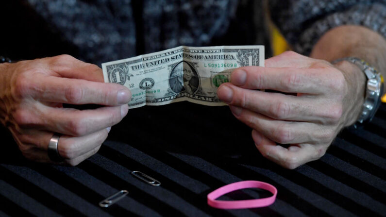 El mago/comediante Murray SawChuck usa un billete de un dólar, una goma elástica y sujetapapeles desde su casa para entretener a las personas que se quedan en casa por las órdenes para combatir la propagación del coronavirus, el 25 de abril de 2020, en Las Vegas, Nevada. (Ethan Miller/Getty Images)