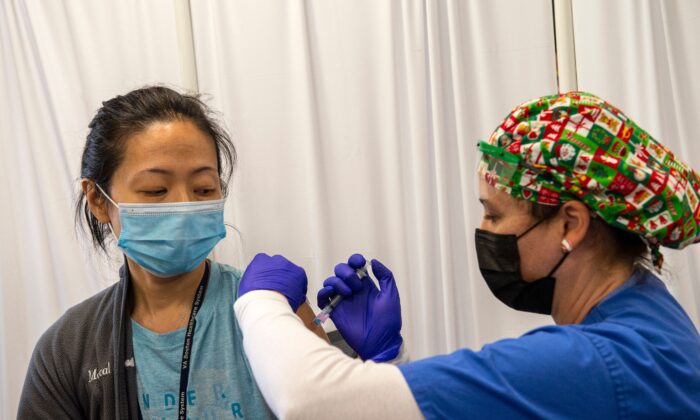 La enfermera y veterana del ejército, Renee Langone, administra una vacuna anti-COVID de Moderna a la Dra. Pei-Chun McGregor de la Fuerza Aérea de EE.UU. (Reservista en servicio activo) en el Centro Médico West Roxbury VA en Boston, Massachusetts, el 23 de diciembre de 2020. (Joseph Prezioso/AFP a través de Getty Images)