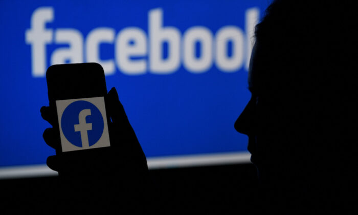 La pantalla de un smartphone muestra el logotipo de Facebook con el fondo de la página web de Facebook, en Arlington, Virginia, el 7 de abril de 2021. (Olivier Douliery/AFP vía Getty Images)