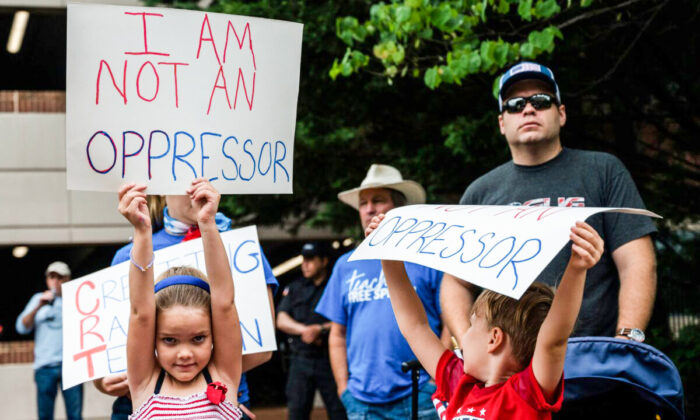 Unos niños sostienen unas pancartas durante una manifestación contra la teoría crítica de la raza que se enseña en las escuelas del centro gubernamental del Condado de Loudoun en Leesburg (Virginia) el 12 de junio de 2021. (Andrew Caballero-Reynolds/AFP vía Getty Images)