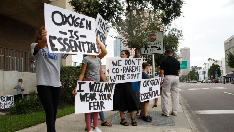 Las familias protestan contra cualquier posible obligación de usar mascarillas antes de la reunión de la Junta Escolar del Condado de Hillsborough celebrada en la oficina del distrito el 27 de julio de 2021 en Tampa, Florida. (Octavio Jones/Getty Images)
