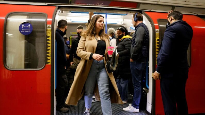 Viajeros, algunos de ellos usando mascarillas, salen de un tren subterráneo de Transport for London (TfL) en Londres el 20 de octubre de 2021. (Tolga Akmen/AFP vía Getty Images)