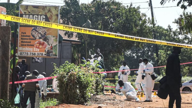 Agentes de la policía ugandesa investigan en la escena del crimen después de una explosión anoche en Kampala el 24 de octubre de 2021. (BADRU KATUMBA/AFP vía Getty Images)