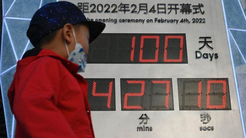 Un niño pasa junto a un reloj de cuenta regresiva que muestra los 100 días que faltan para la inauguración de los Juegos Olímpicos de Invierno de 2022, en un complejo de centros comerciales en Beijing el 27 de octubre de 2021. (Jade Gao/AFP vía Getty Images)