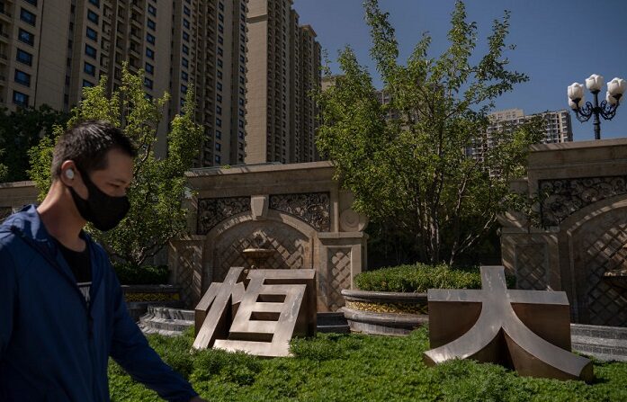 Un hombre pasa junto a los caracteres HengDa (Evergrande en chino) en la entrada de un complejo residencial construido por Evergrande el 22 de septiembre de 2021 en Beijing, China. (Andrea Verdelli/Getty Images)