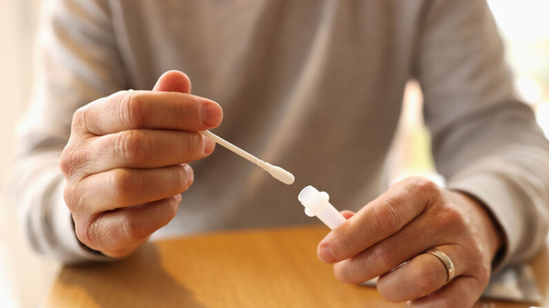 Hombre usa un kit de prueba rápida de antígeno COVID-19. (Cameron Spencer/Getty Images)
