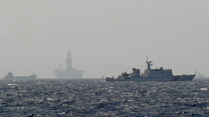 Esta foto tomada el 14 de mayo de 2014 desde un barco guardacostas vietnamita muestra un buque guardacostas chino (dcha.) navegando cerca de una plataforma de perforación petrolífera de China en aguas disputadas en el mar de China Meridional. (Hoang Dinh Nam/AFP vía Getty Images)