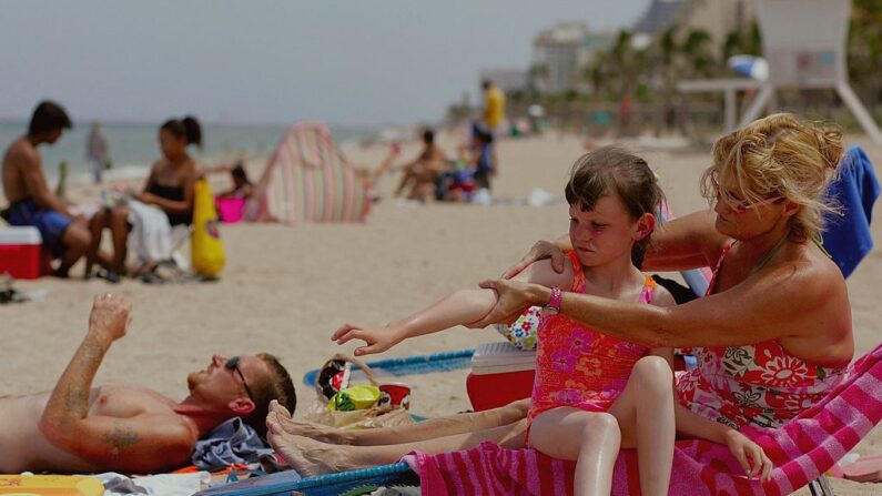 Sharon Doyle pone protector solar en el brazo de Savannah Stidham, de 9 años, mientras visitan la playa el 20 de junio de 2006 en Fort Lauderdale, Florida. (Joe Raedle/Getty Images)