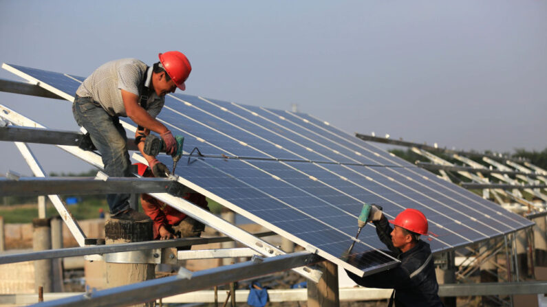 Los trabajadores instalan paneles solares en el sitio de construcción del proyecto de energía fotovoltaica en red de 40MW en Huai an, China, el 11 de junio de 2018. (VCG/VCG vía Getty Images)