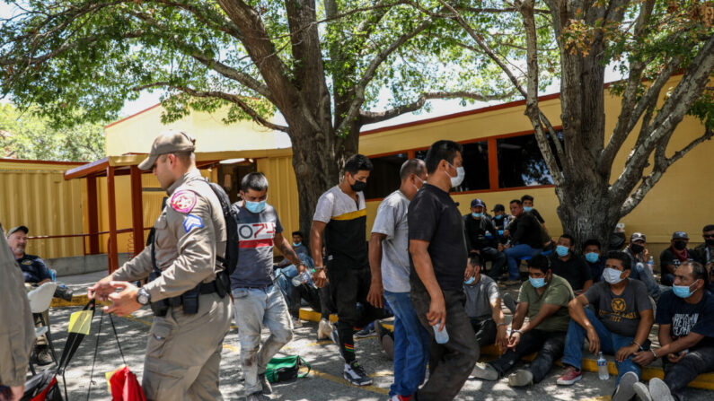 Un total de 52 inmigrantes ilegales de México y Honduras esperan ser registrados por allanamiento luego de ser arrestados por la Policía Estatal de Texas en ranchos locales, en la Oficina del Sheriff del Condado de Kinney en Brackettville, Texas, el 8 de agosto de 2021. (Charlotte Cuthbertson/The Epoch Times)